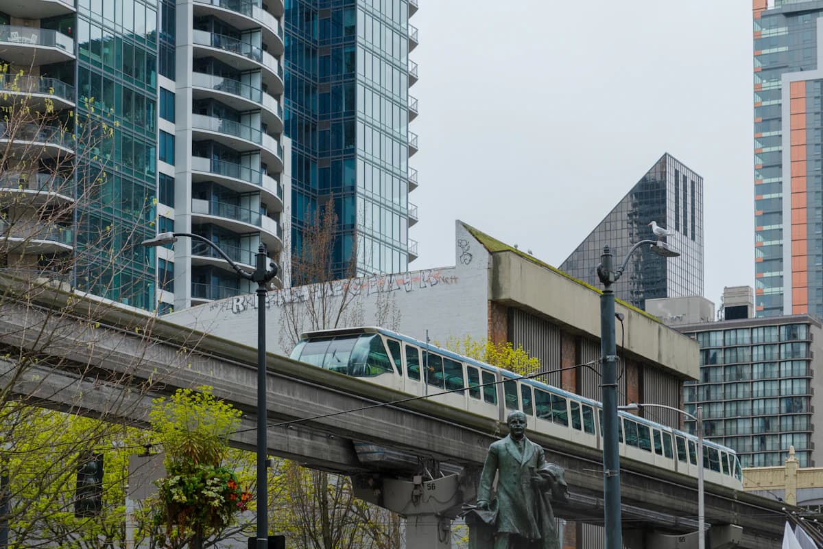 LA Metro train on an elevated track beside tall buildings