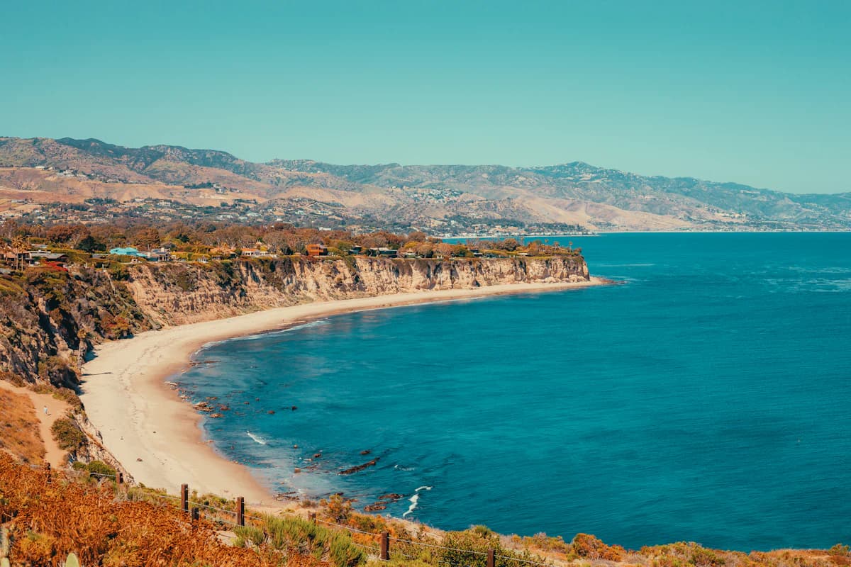 Turquoise cove along the Malibu coast with hills behind