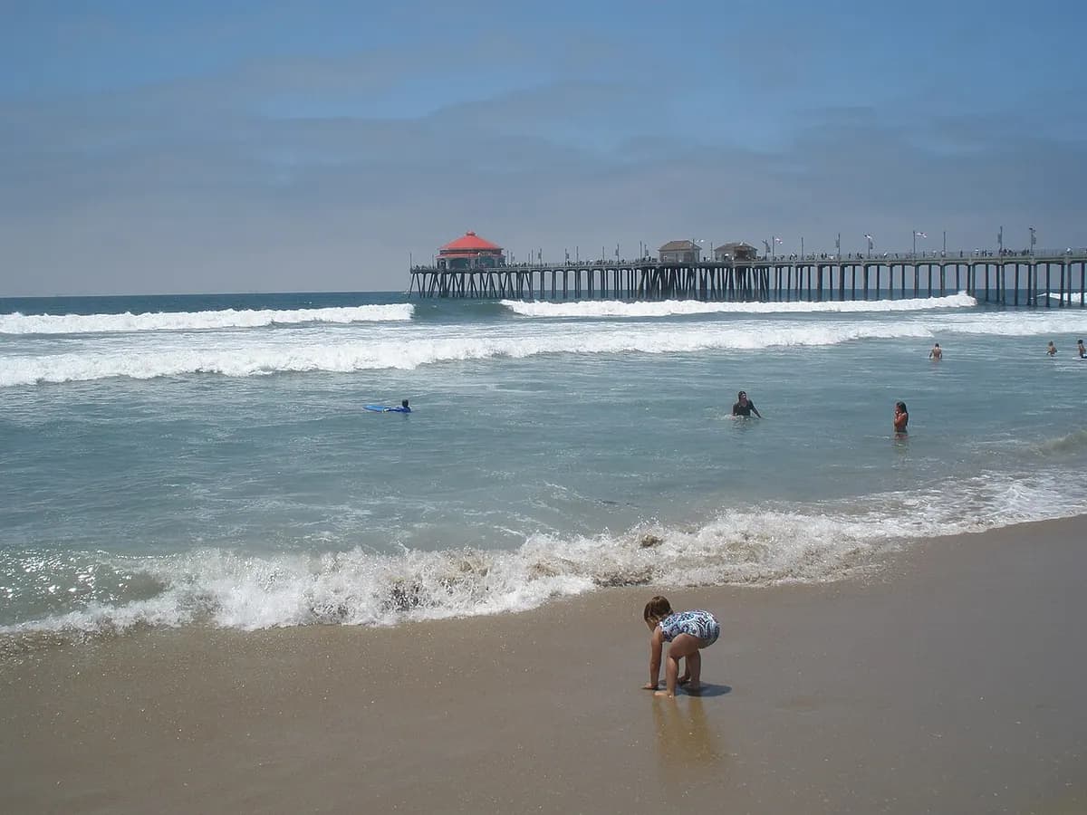 Huntington Beach Pier with surfers and swimmers